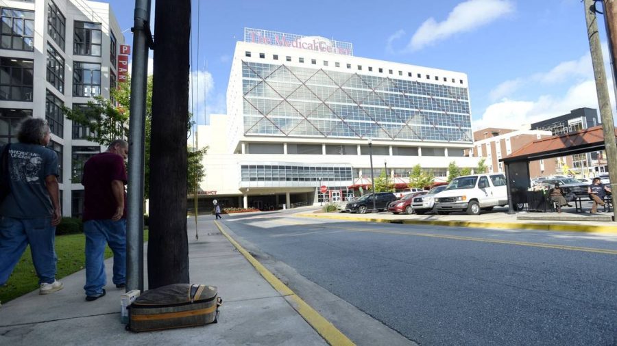 People passing by the Macon Transit Authority bus stop in front of the Medical Center, Navicent Health, on July 5, dont bother a suitcase left there. The Macon-Bibb County commissioners cut funds for indigent care to the hospital in the most recent revised budget