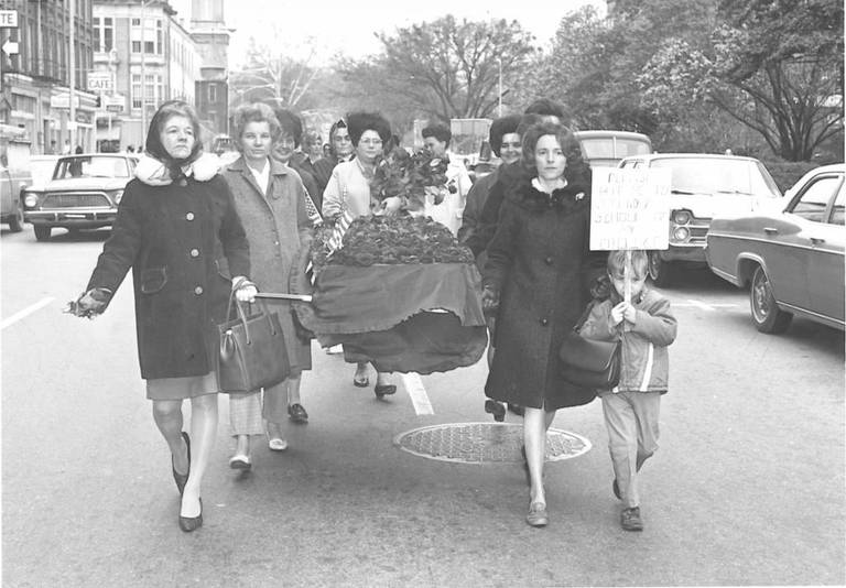 After court orders to integrate the Bibb County school system, protesters marched on the federal courthouse in 1970 carrying a fake coffin to symbolize buried freedoms. The sign the child is carrying reads: Please help me to attend a school of my choice.