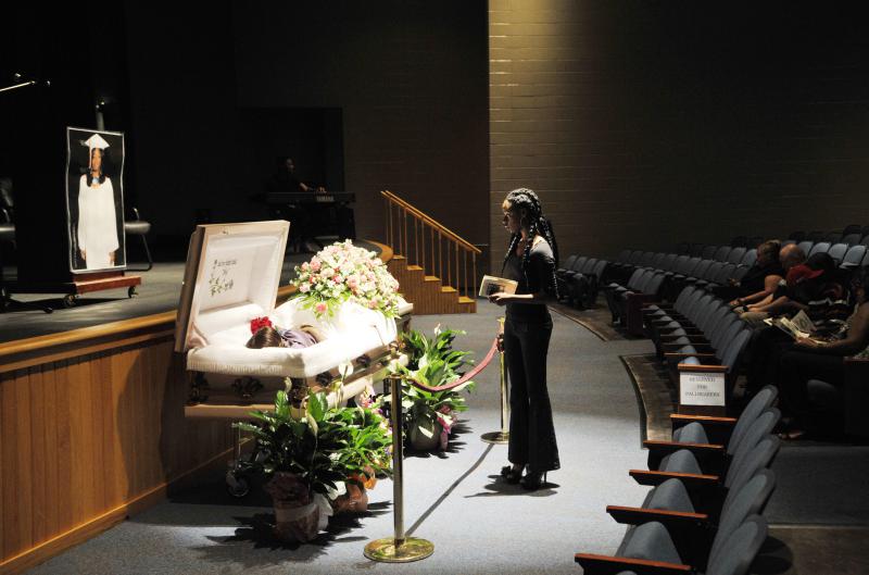 Shaquavia Woodard pauses at the casket of her former classmate SharBora YanKita Shyrell Daniels before Daniels funeral in the auditorium of Central High School in Macon in 2012.