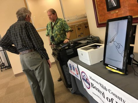 Macon-Bibb County elections officer Tom Gillon, center, demonstrates how to operate voting machines at the board of elections office in this file photo. Gillon is the interim elections supervisor following Jeanetta Watsons retirement.