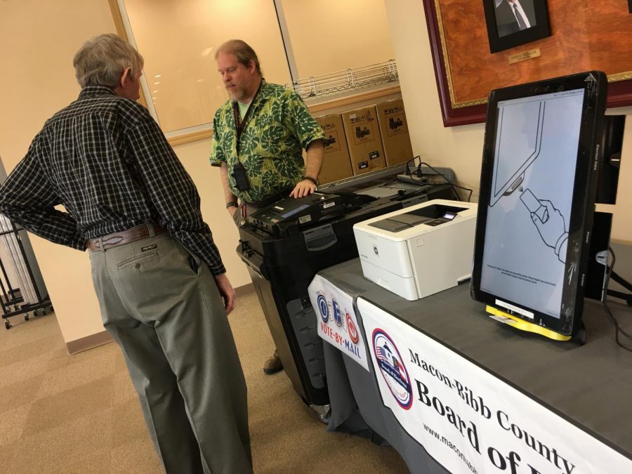 Macon-Bibb County elections officer Tom Gillon, center, demonstrates how to operate voting machines at the board of elections office in this file photo. Gillon is the interim elections supervisor following Jeanetta Watson's retirement.