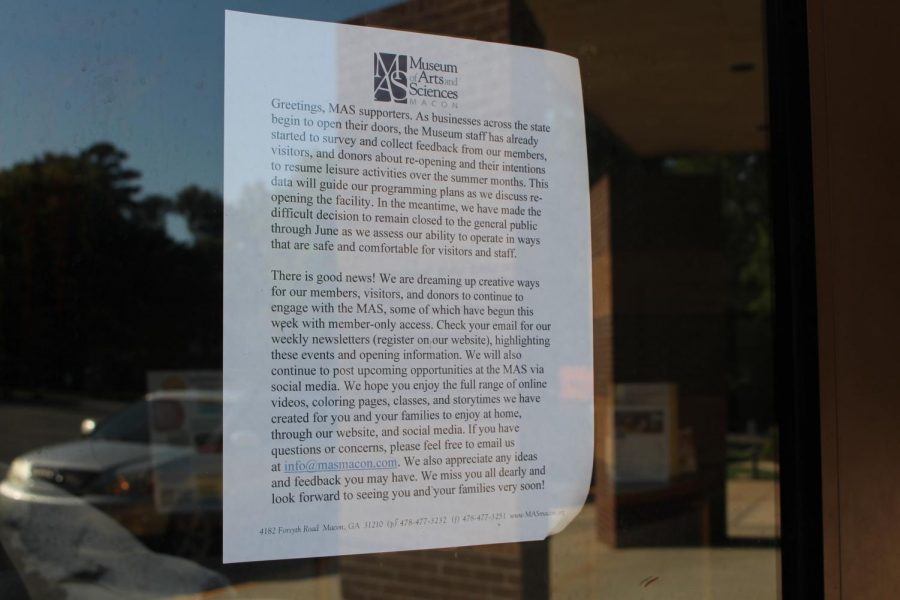 A piece of paper describes how the Museum of Arts and Sciences has been closed due to the pandemic. The contents of the paper are barely readable and the purpose of the image is to show that the paper has been taped to the door.