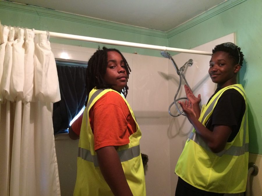 Lynmore Estates Ambassadors show off their work in a neighbors bathroom during a workday. 