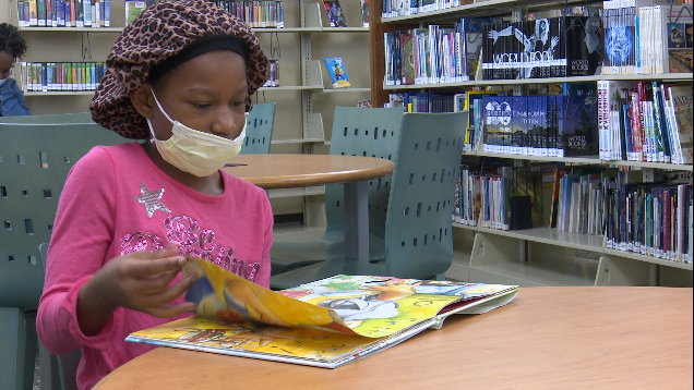 Romaya, 10, takes a break from virtual learning to read a book at the Washington Memorial Public Library.