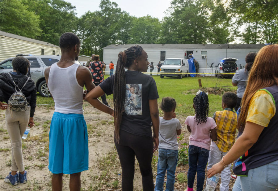 Family and neighbors of Quinterious Hillman and Jerod Lester watch as Bibb County Sheriffs Deputies investigate the scene of Hillman and Lesters killing in May.