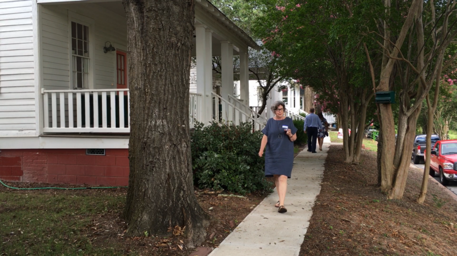 Mill Hill East Macon Arts Village resident Cassie Bryant walks to a reception after showing Mayor Lester Miller her home last month. 