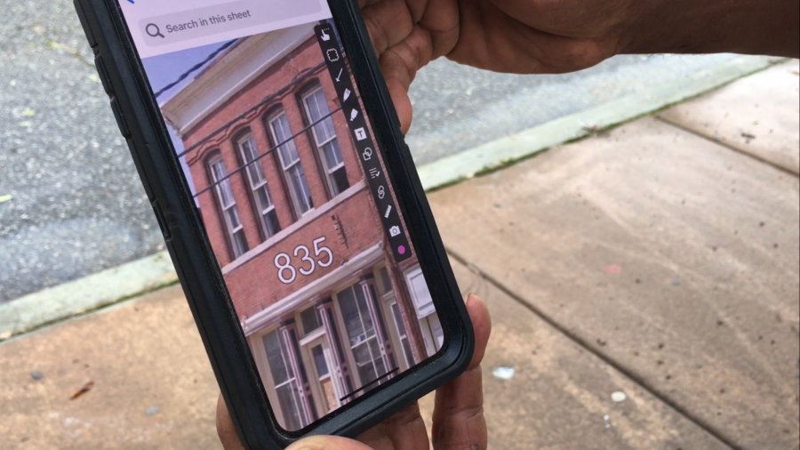 Builder Shawn Stafford looks at a photo of 835 Forsyth St. before the facade collapsed late Monday night in downtown Macon. 