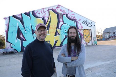 Owner Ric Geyer (left) and Executive Manager Colin Penndorf stand in front of one of Nel’s pieces at Triangle Arts, a 40x60ft tag. 
