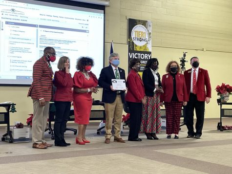 The Bibb County School Board stands together for a photo during the last meeting of 2021. School Board President Daryl Morton, center, holds a Quality School Board certificate from the Georgia School Board Association.