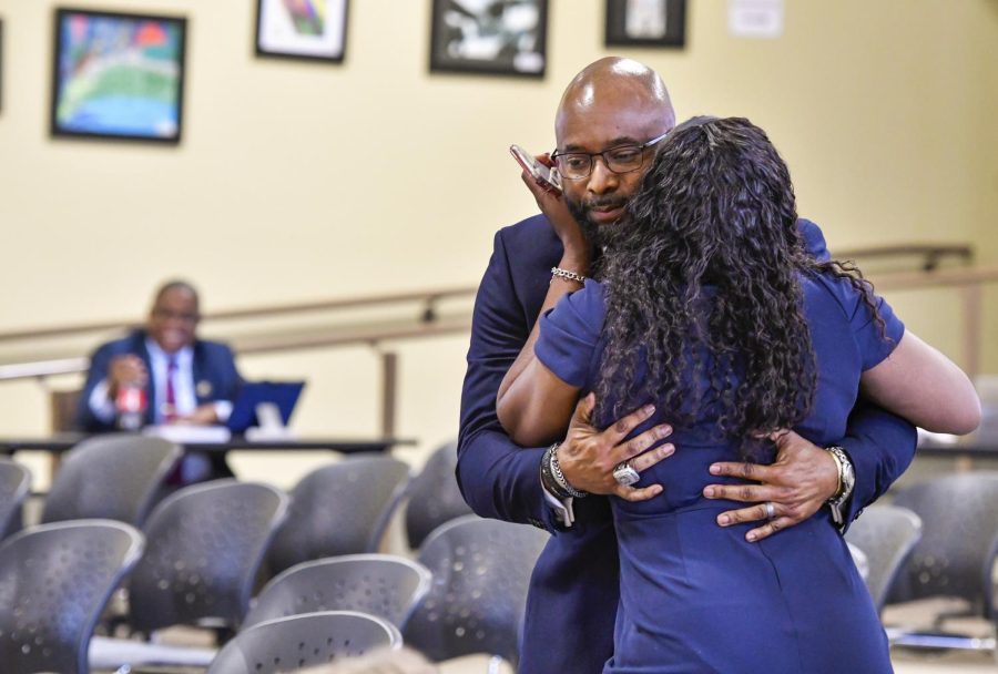 Dan Sims hugs his wife, Traci, after the Bibb County Board of Education voted 6-2 to appoint him to superintendent.