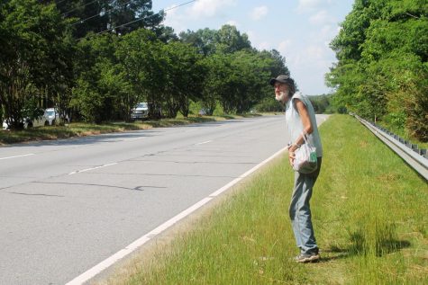 Thomas Bemke, 60, walks a mile through knee-high weeds on the shoulder of Gray Highway in 90-degree heat one day early in May 2022 to buy groceries at Dollar Tree. Bemke said he is extra cautious on his trek because of the number and speed of semis on the highway.