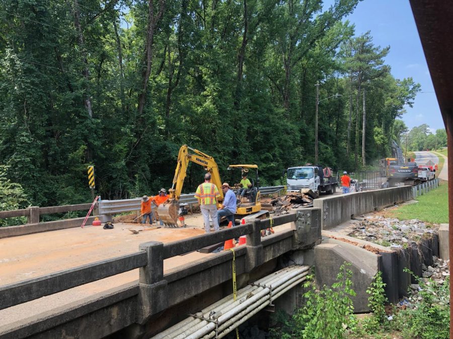Crews work Friday to repair a washed out approach to the bridge on Log Cabin Drive. 