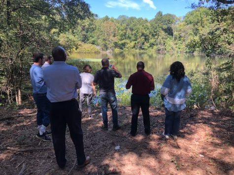 Macon-Bibb County Mayor Lester Miller, center, takes a sip of water as county leaders gaze on Cliffview Lake, the site of one of the countys newest passive park projects. 