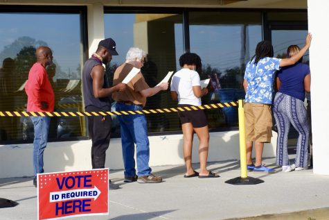 Voters wait in line on the first day of early voting in front of the Bibb Country Board of Elections Office. (Photo by Eliza Moore)