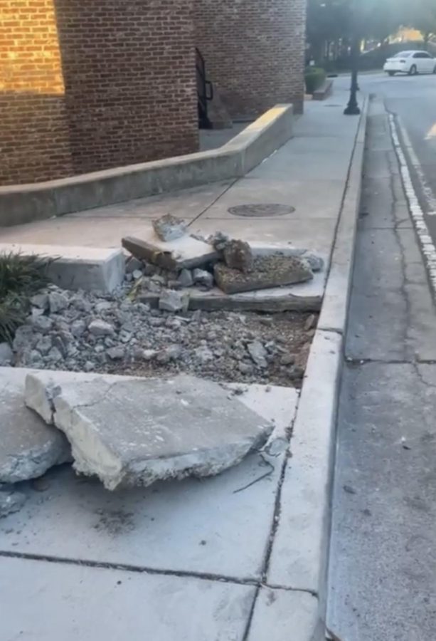 An area of sidewalk about three feet by three feet lays in ruins after being destroyed to repair it. No contruction workers or notices are in sight.