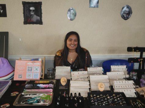 Student sitting behind table jewelry and other items