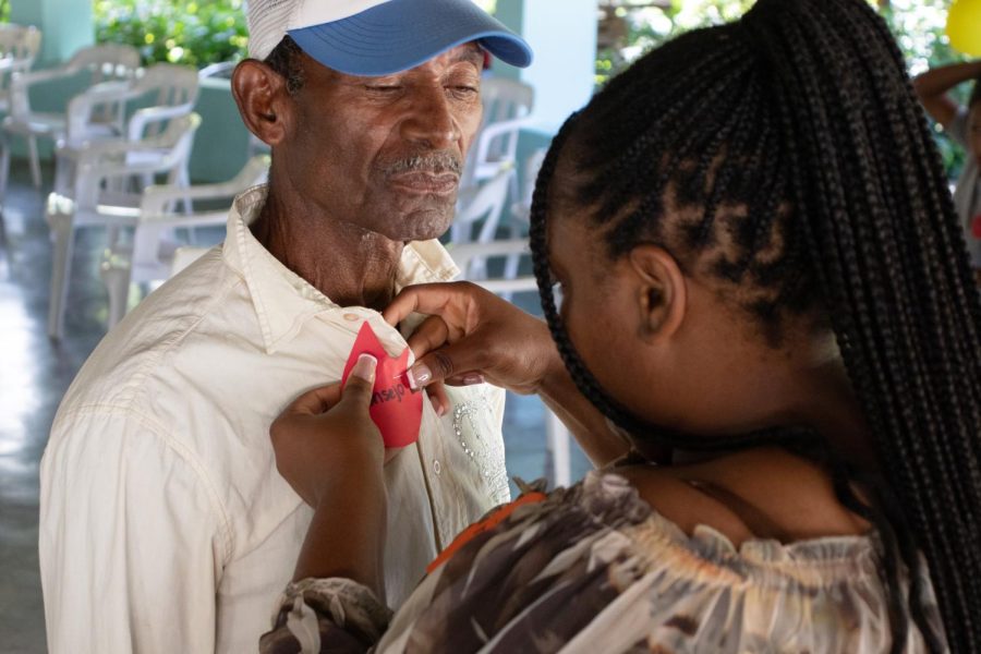 Fatoumata Keita, a Mercer engineering student, pins a tag onto a community member’s shirt at the Pentecost celebration at Villa Andres in El Cercado, Dominican Republic on June 11, 2023. The tag reads “consejo” which translates to “advice” in English. The annual occasion celebrates the Holy Spirit and this year they focused on revitalizing the Christian-based communities. 