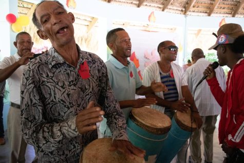 Three members of the community play the palos (drums) and sing while the community dances around them. The palos are a large part of Dominican heritage and are used during celebrations of death as well as celebrations of the Holy Spirit, among other celebrations.