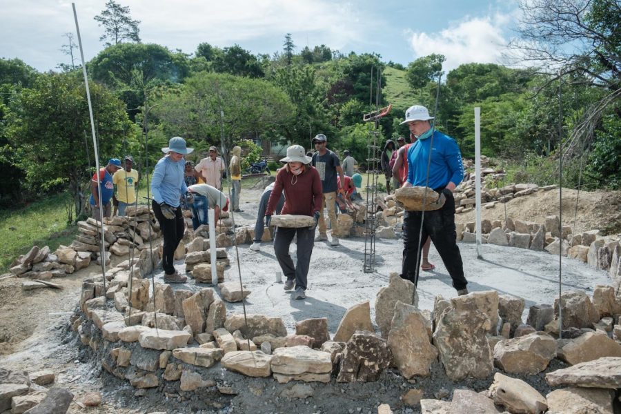 Mercer University engineering students Emily Jacobson (center) and Timmons Johansen (right) work side-by-side with members of the Sabana Bonita community in El Cercado, Dominican Republic to construct a stone water tank. The new tank will provide water to 88 families.