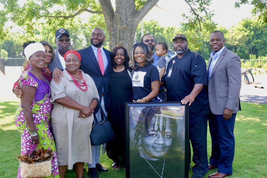 Family and community members pose with a photo of the late Frankie E. Lewis on Tuesday, June 6, 2023, at the ribbon-cutting for the new park.
