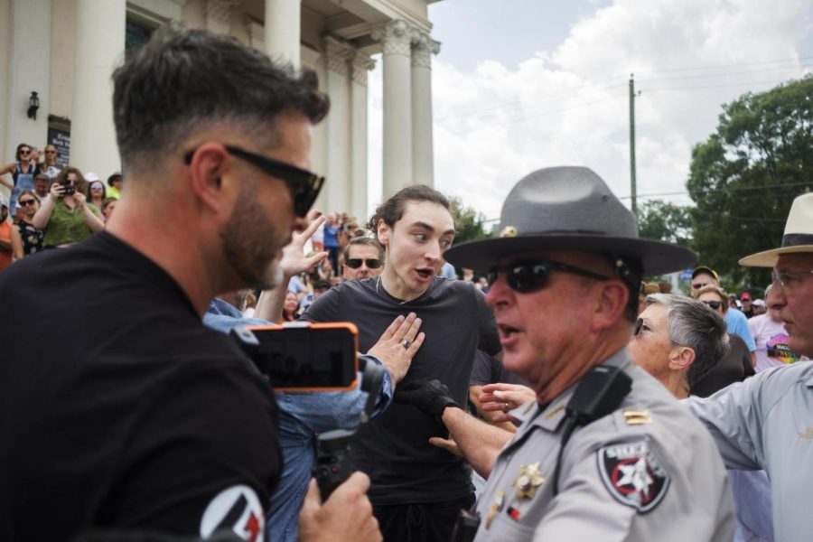 A supporter of Macons Temple Beth Israel, center, is held back by law enforcement as the leader of a documented antisemitic hate group, left, attempts to disrupt a gathering at the temple on Saturday, June 24. The gathering was in response to the hate groups action at the temple the day before at the start of the Jewish Sabbath.