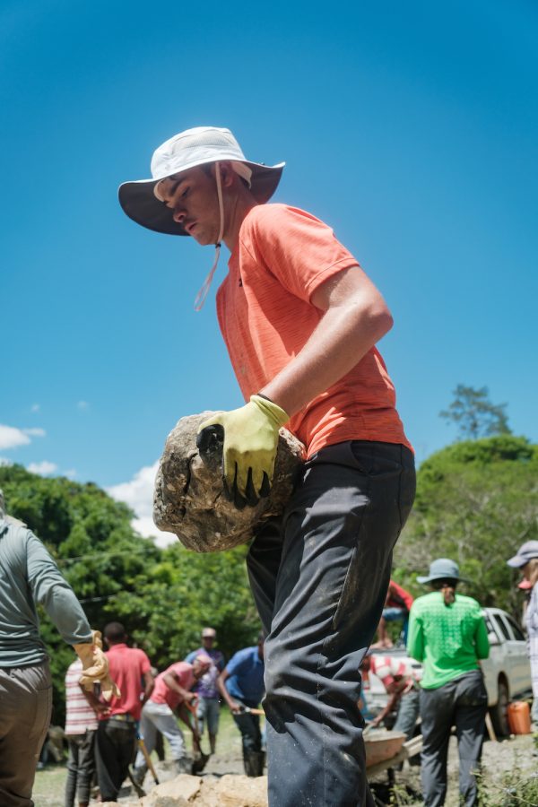 Mercer engineering student Nicholas Buccelli carries a large rock that is being used to construct the walls of a stone water tank in the Sabana Bonita community of El Cercado, Dominican Republic. Mercer worked in the community from May 31 to June 17, 2023.