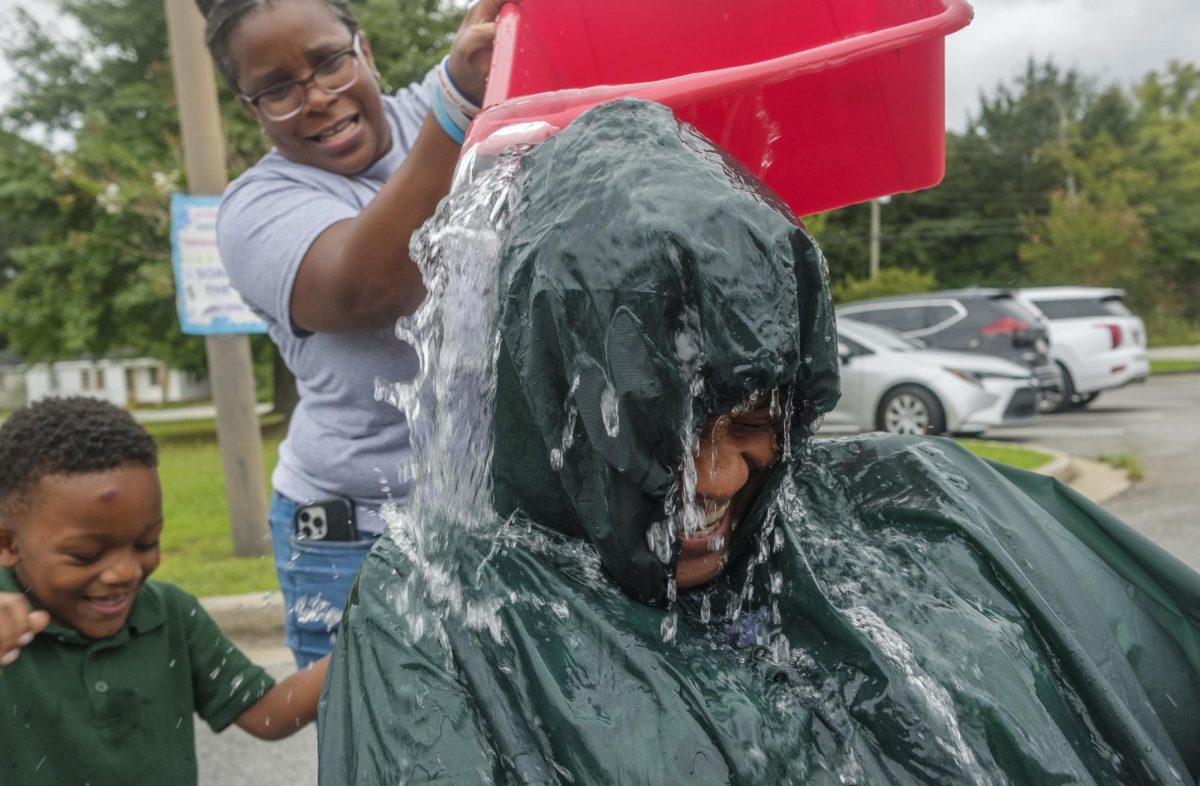 Bruce Elementary School Principal Kizzie Lott endures one of about 20 dumps of water on her head courtesy of students with good school attendance. It was one of the periodic rewards Lott gives students to incentivize them and their parents to prioritize school attendance.