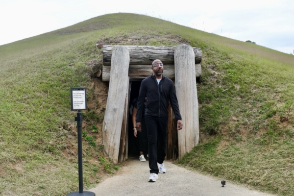 Sen. Raphael Warnock exits the Earth Lodge, a relic of Mississippian culture from over 1,000 years ago, during his tour of the Ocmulgee National Historic Park on Nov. 20, 2023.