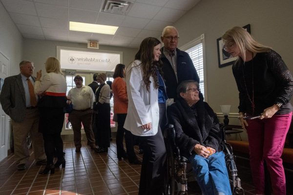 Medical student Emily Hartley from Reynolds, Ga., talks to her neighbors at the ribbon-cutting for the Mercer Medicine clinic in Taylor County, bringing local health care to the rural area for the first time in a decade.