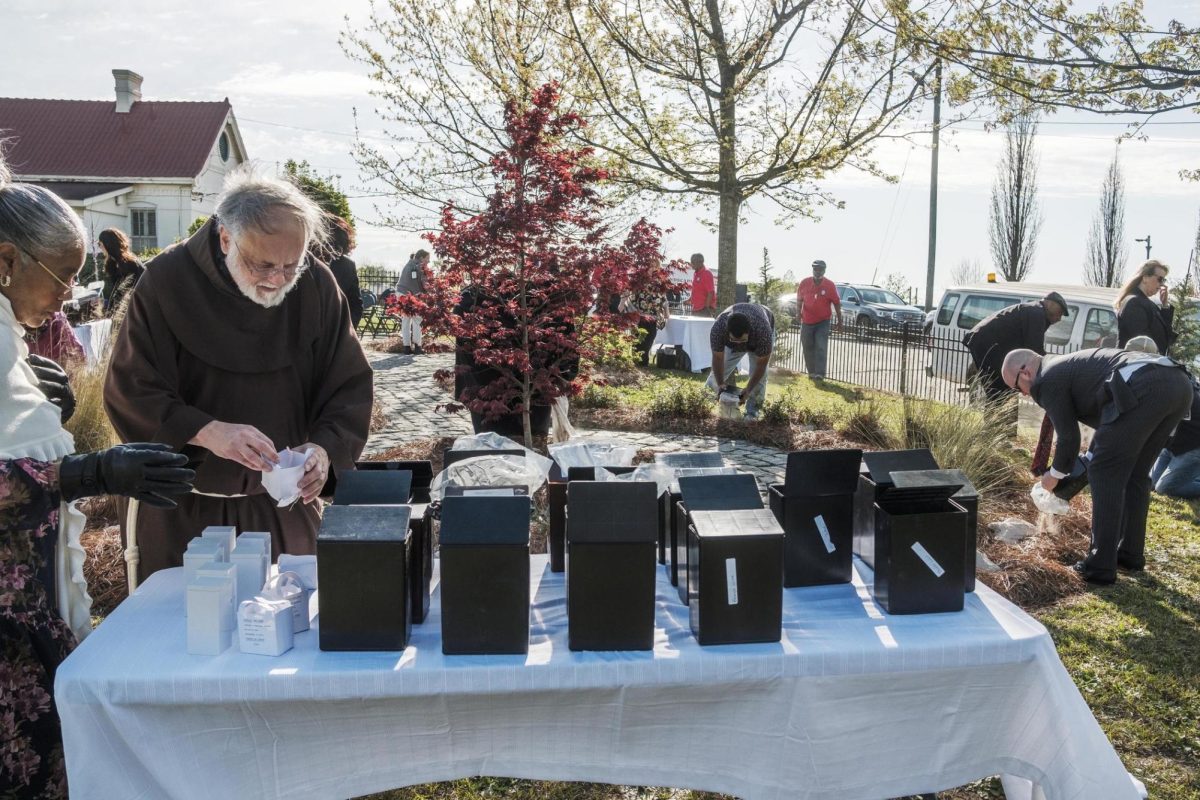 People scatter hundreds of sets of unclaimed cremated human remains around a small garden at Macon's Rose Hill Cemetery during a short ceremony on Thursday, March 28, 2024.
