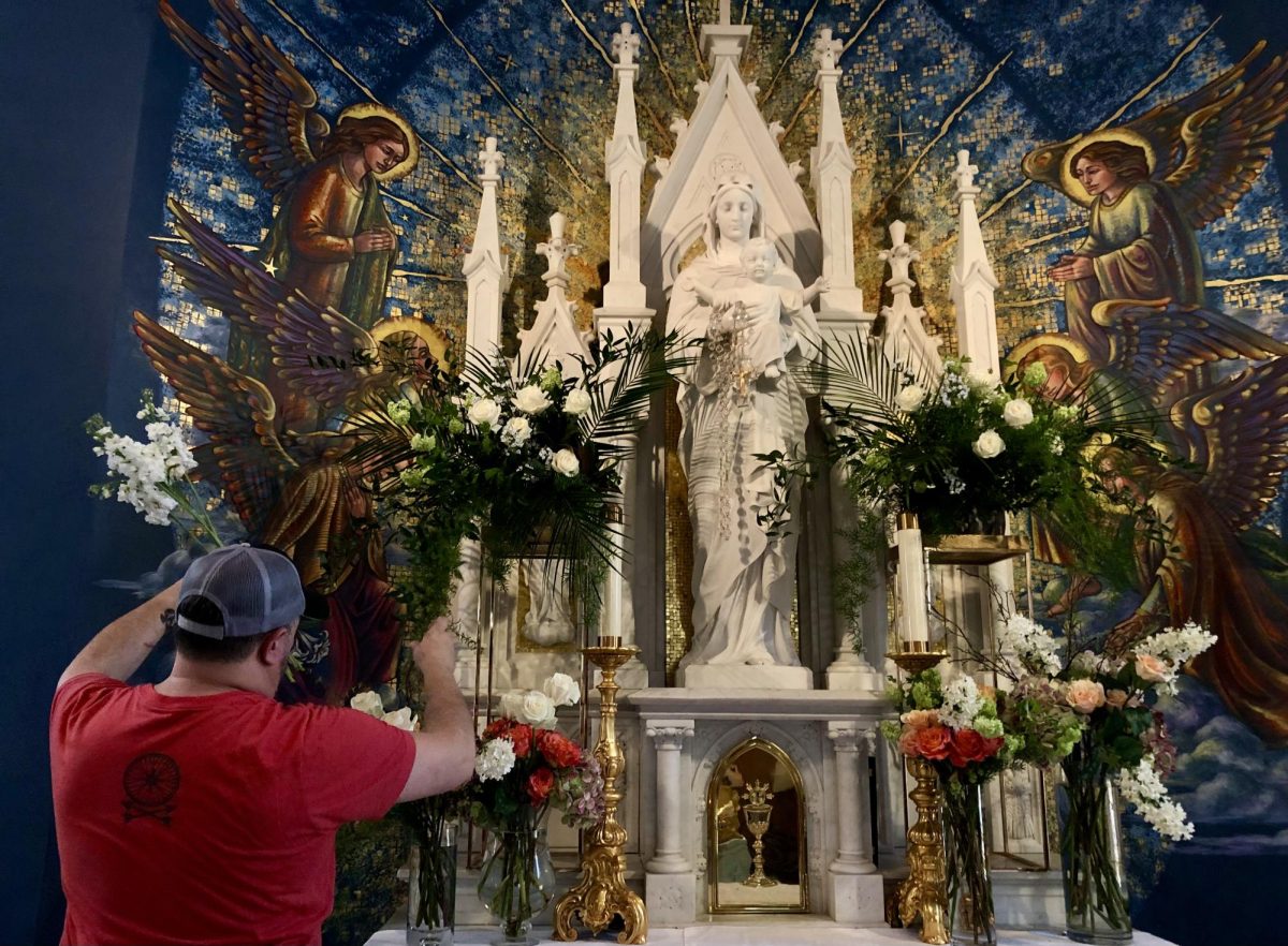 Mulberry United Methodist Churchs Chris Abbott places flowers in the Blessed Mother Chapel of St. Joseph Catholic Church for the Old City Flower Festival March 15-18.