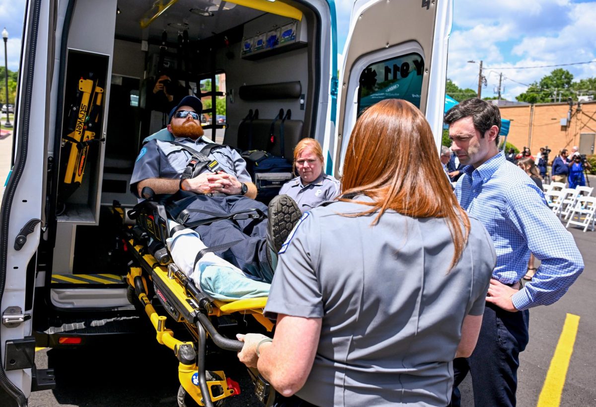 U.S. Sen. Jon Ossoff gets a demonstration of a hydraulic stretcher in one of the new Atrium Health Navicent ambulances from EMT Josh Humphrey and paramedics Kerry Sanders, back, and Jeannie Middlebrooks on Monday, April 22, 2024.