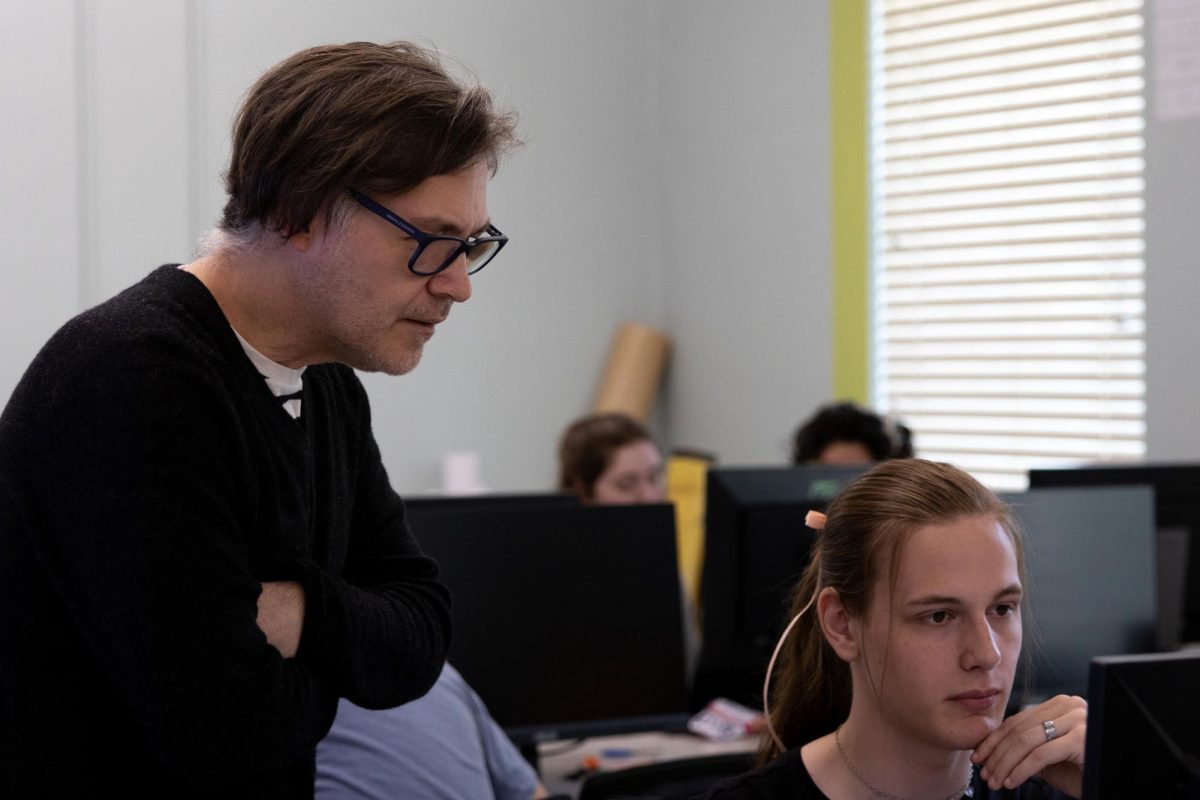 Coleman (left) helps art student Ellis Eley (right) use Adobe Photoshop in Mercer University graphic design class on Thursday, April 15, 2024.