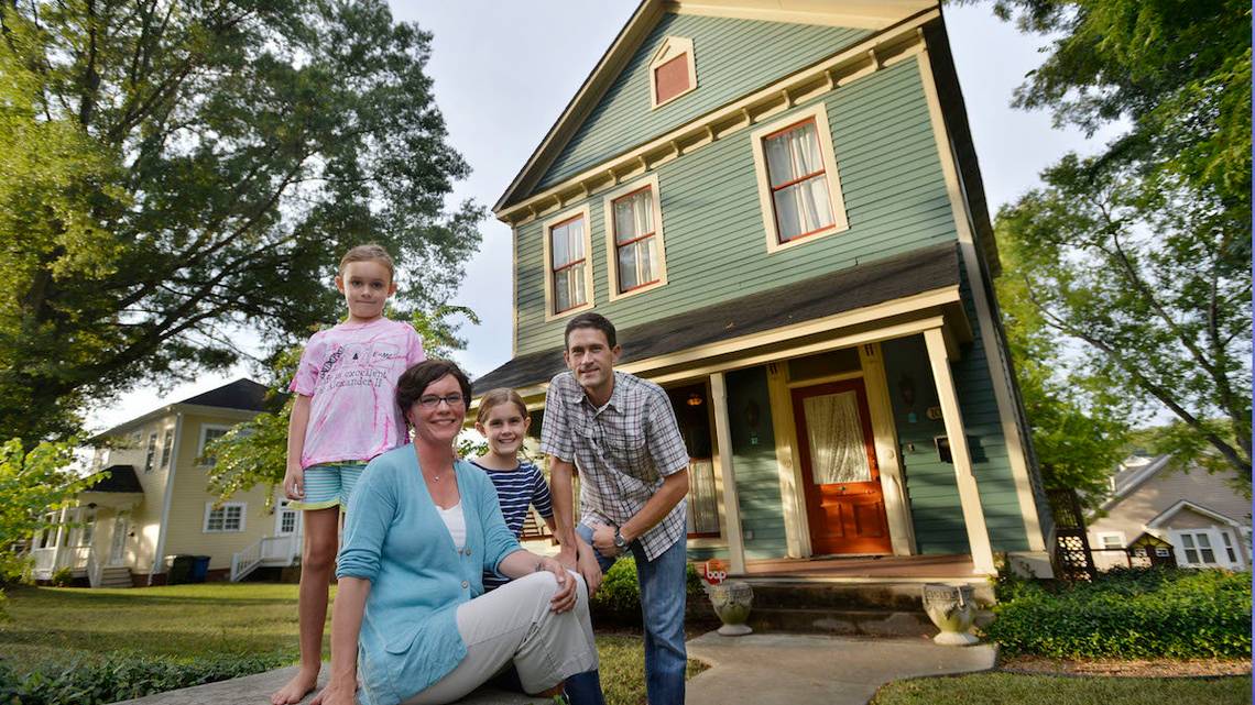 Craig Byron and wife, Ellen, and their daughters, Julia, 7, and Grace, 10, in front of the family's renovated home on Ash Street. The family is shown here in a 2014 photo.