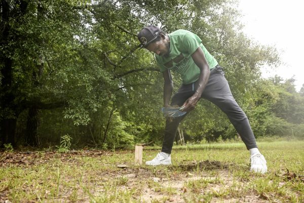 Rodney Mason collects scoops of soil to test from the vacant lot in Kings Park Subdivision where he will grow indigenous cultivars in a neighborhood garden. 