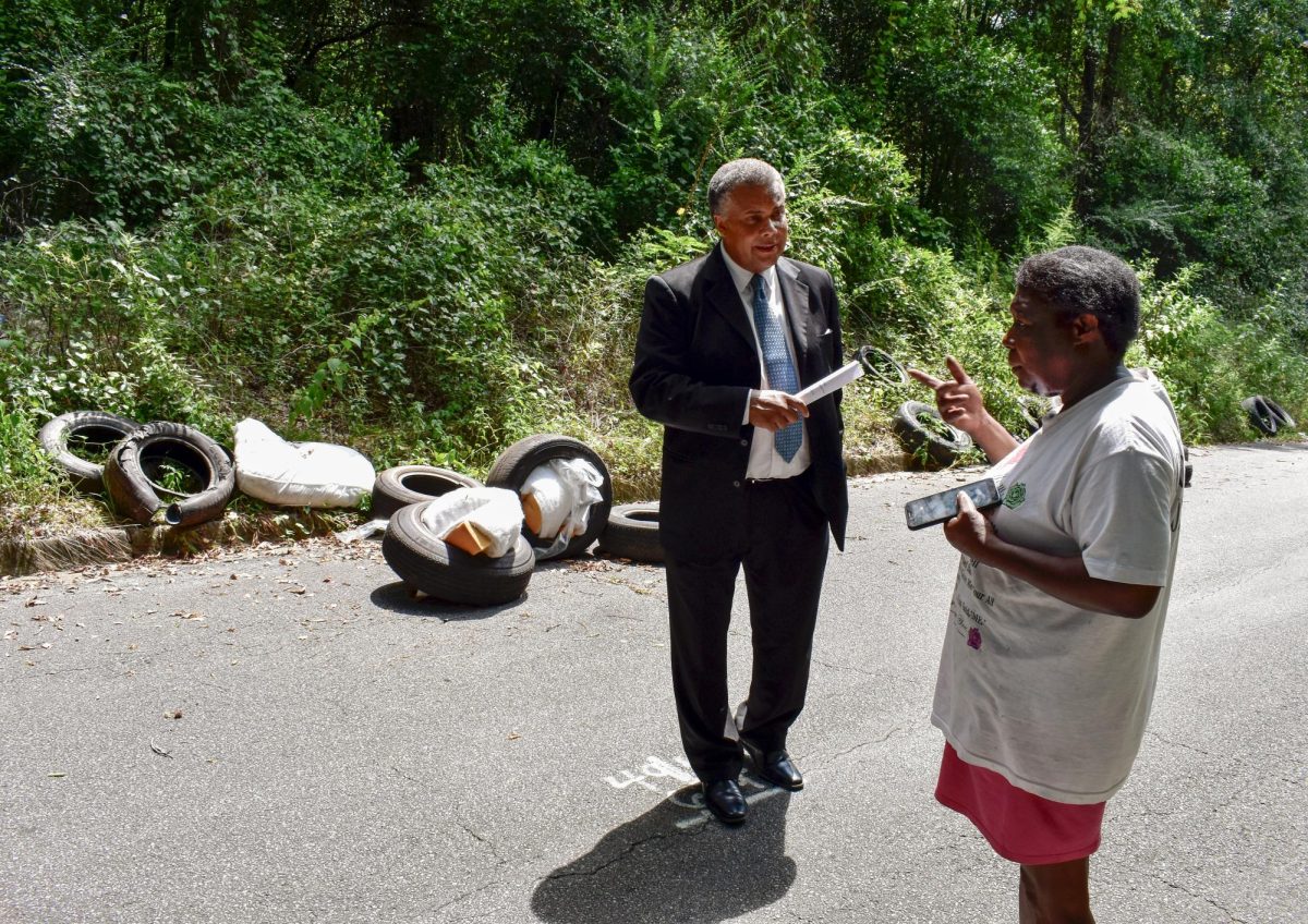 District 3 Macon-Bibb County Commissioner-elect Stanley Stewart talks with Vanessa Smith as she strolled down Central Street in the Fort Hill neighborhood Monday. The area is a hot spot for illegal dumping.