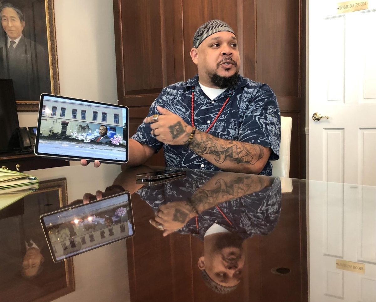 Muralist Kevin "Scene" Lewis shows a Keep Macon-Bibb Beautiful committee his plan for a Martin Luther King Jr. Mural in the 1400 block of MLK Jr. Blvd. near Downtown Macon.  