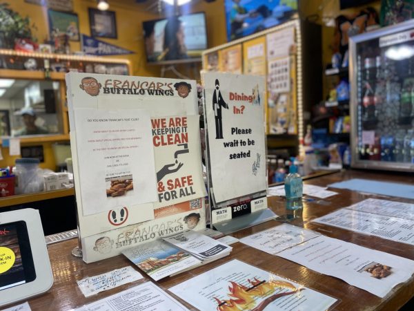 A sign sits in front of the register welcoming entering customers and promoting a text loyalty club at Francar's Buffalo Wings in Macon, Georgia.
