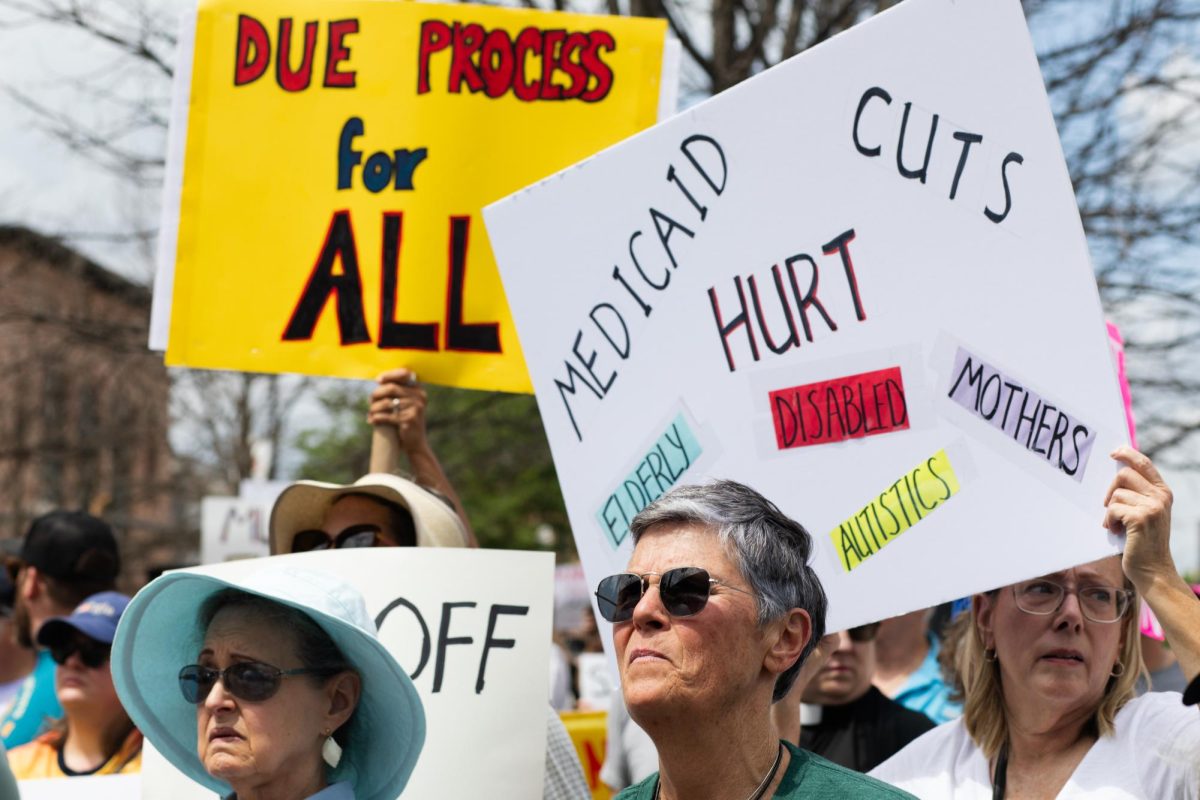 Demonstrators raise signs protesting against Medicaid cuts and calling for due process for all as speakers continue to rally the crowd on April 5, 2025.