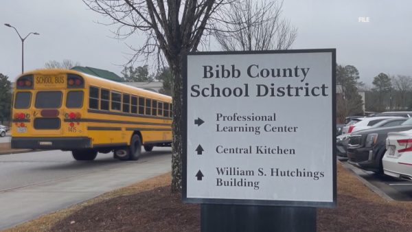 A school bus drives by the W.S. Hutchings College & Career Academy.