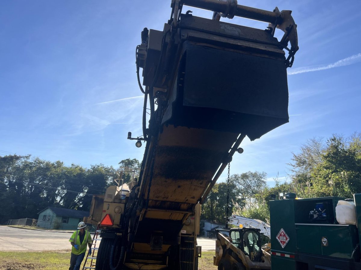 A road crew member sets up equipment for paving work near Mercer University Drive. 
