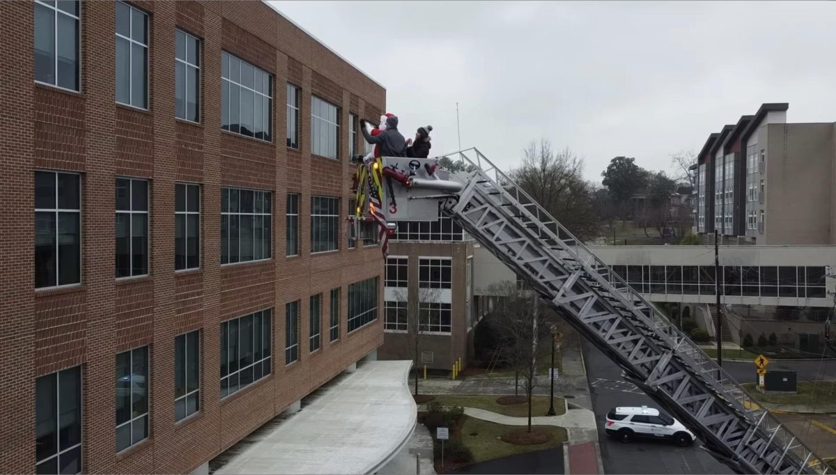 Capt. Phil Herndon dressed as Santa on the aerial ladder to greet the children through their windows.

