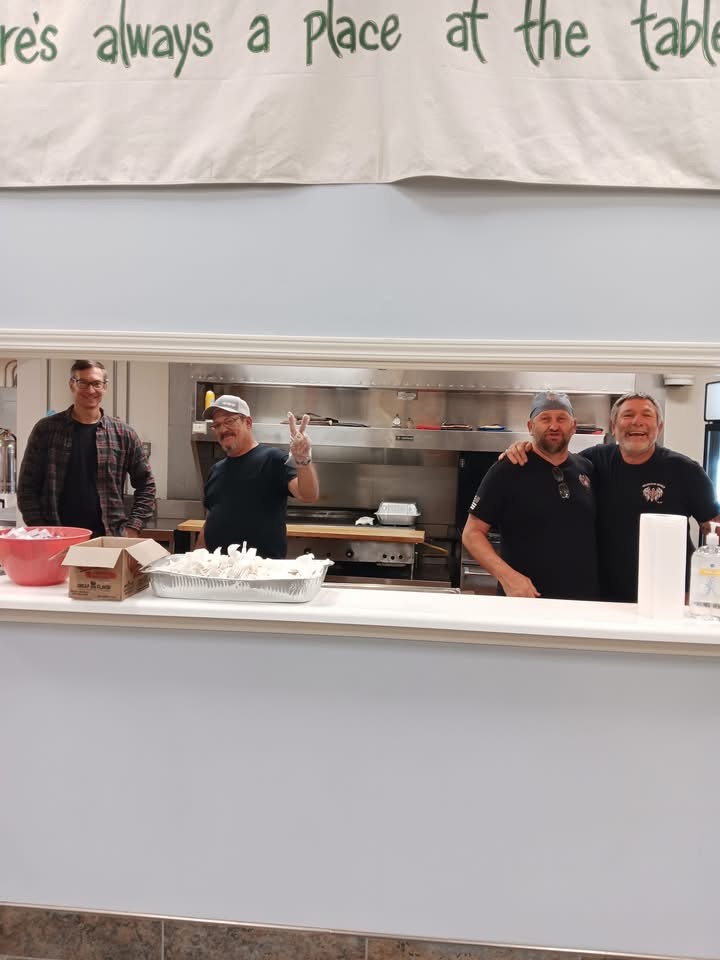 Four volunteers stand in a kitchen preparing for Centenary Church's weekly community breakfast.