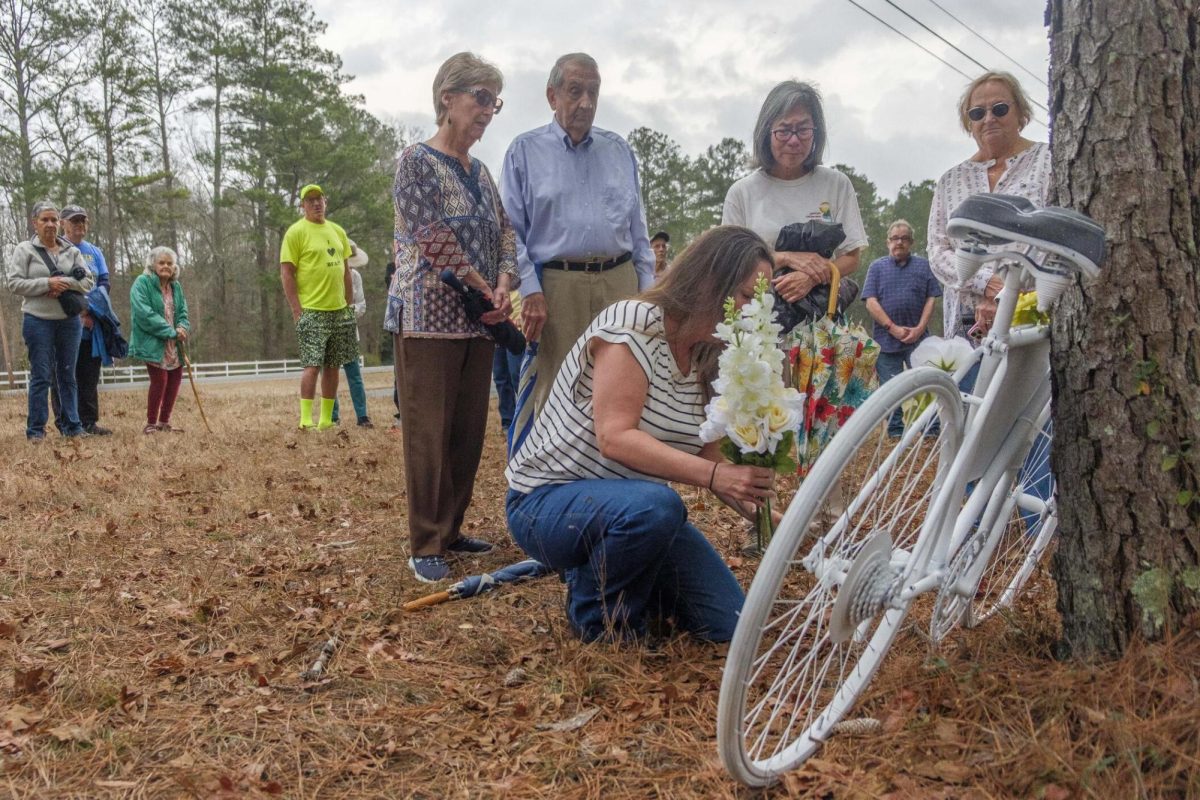 Michael Ryan's family, including his widow Yukiko Ryan (third from right) mourn during the dedication of a ghost bike in his memory in February. The all-white ghost bike memorial signifies a cyclist killed nearby on the road — hopefully bringing attention to the need for safer roadways for cyclists.