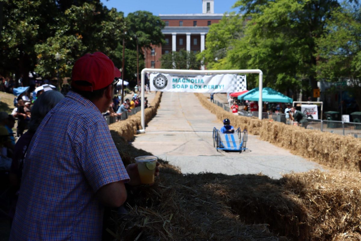 Onlookers stand at the bottom of the hill on Magnolia Street as teams race down at the 16th annual Magnolia Soap Box Derby on Saturday, April 11, 2026. (Photo by Ryleigh Sandefur)