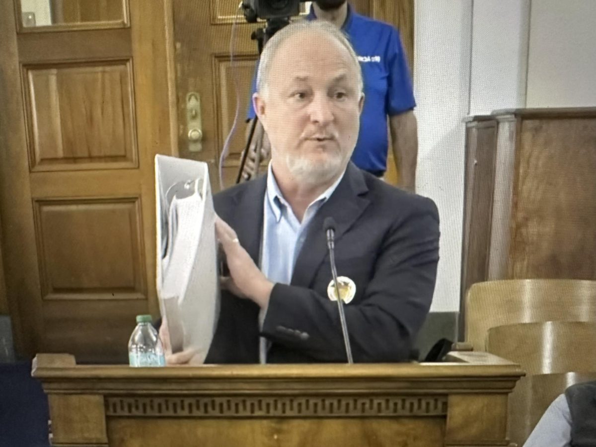 Macon-Bibb County Mayor Lester Miller holds up a binder containing the Fiscal Year 2027 budget he presented to commissioners Tuesday evening.